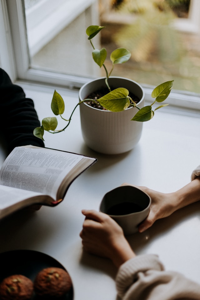 two people having a conversation with the bible open on the table